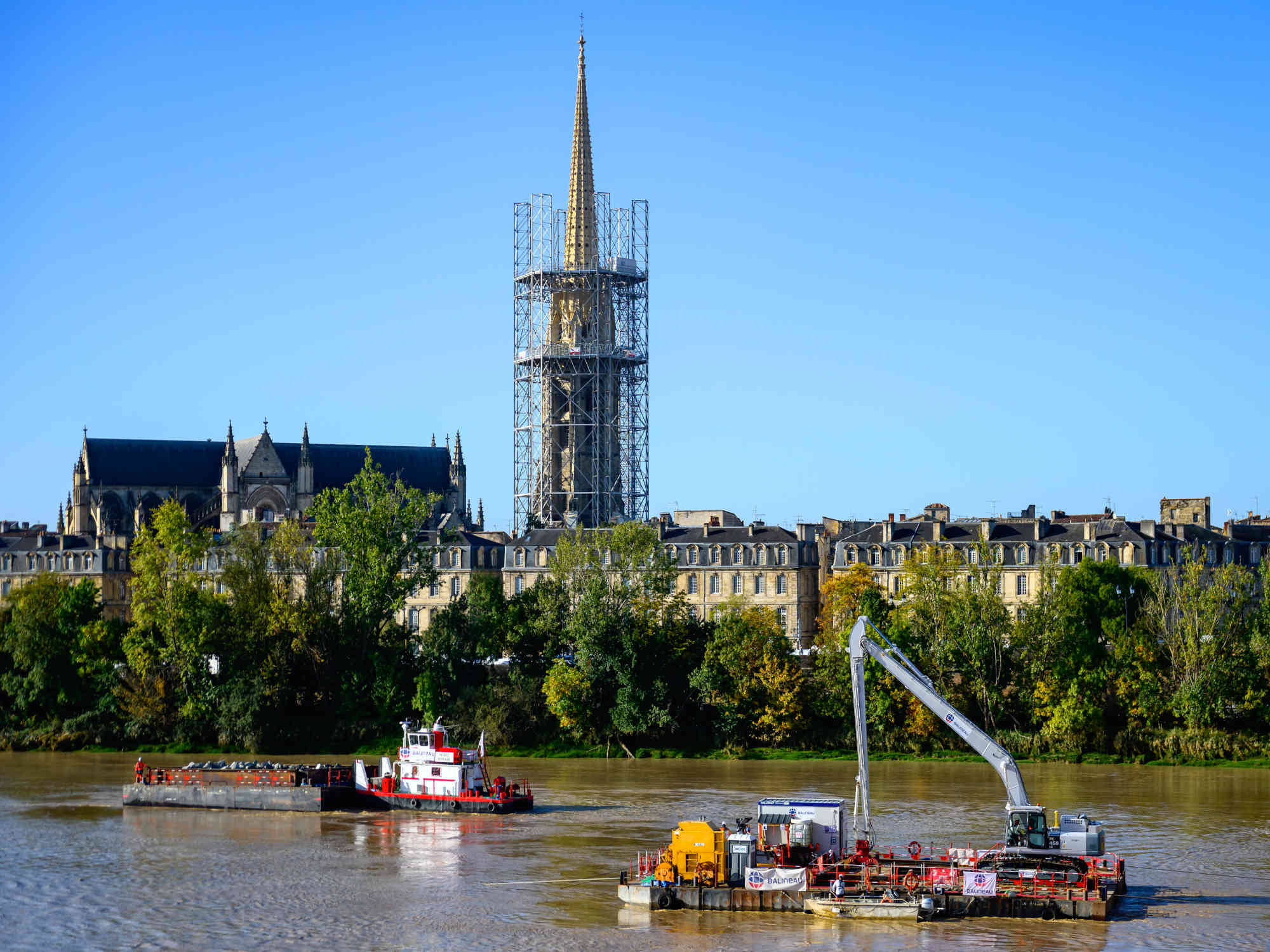 Passage de la barge d'enrochements devant la flèche Saint Michel en rénovation